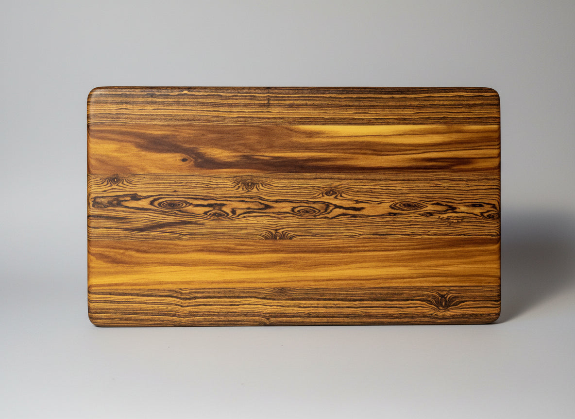 Person holding a wooden cutting board with a decorative pattern against a neutral background